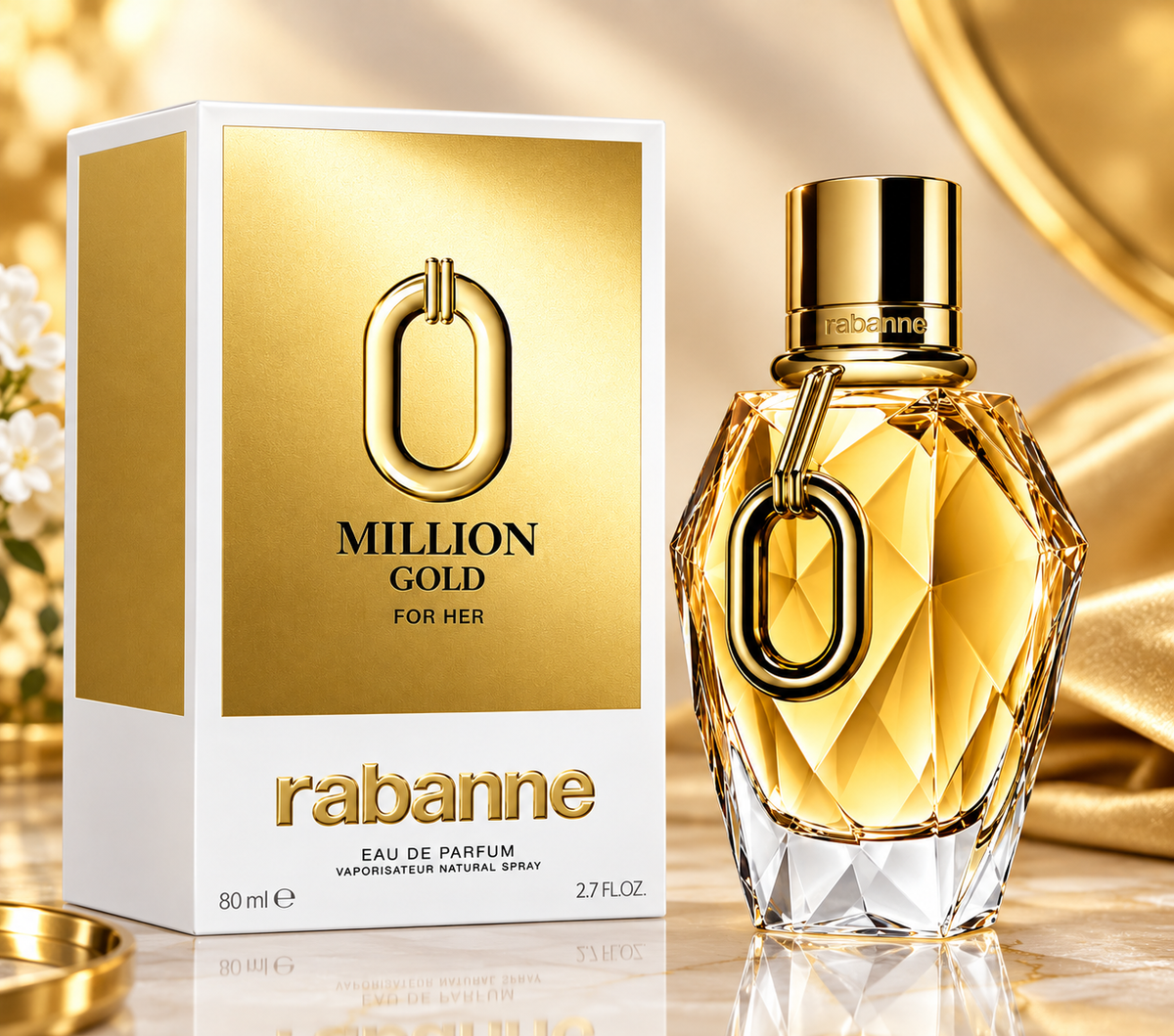 A Rabanne Million Gold For Her perfume set featuring a gold-and-white box beside a faceted gold-toned perfume bottle with a large loop-shaped emblem on the front.