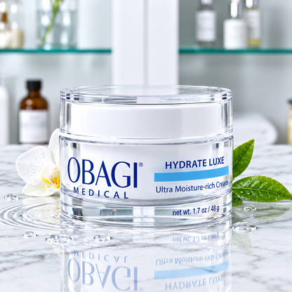 A small clear jar of Obagi Medical Hydrate Luxe Ultra Moisturizing Cream with a white lid and blue-and-white label.